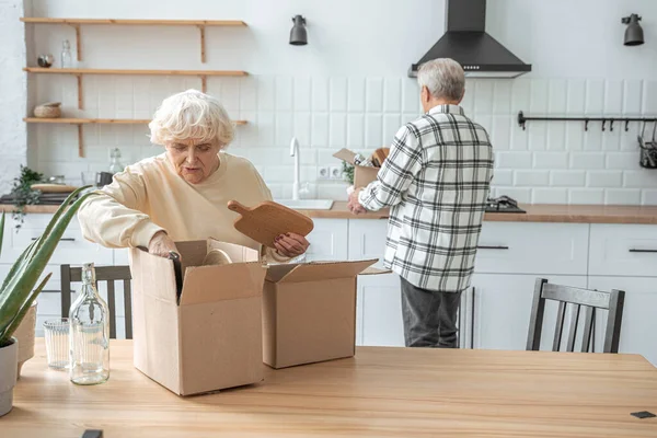Gelukkig ouder paar uitpakken kartonnen dozen in hun nieuwe huis — Stockfoto