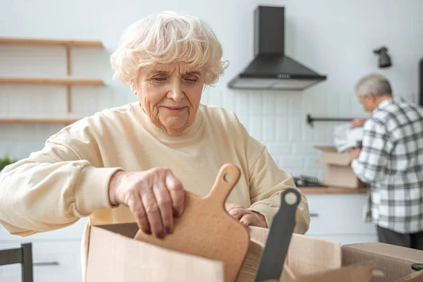 Mature caucasian woman moving in to new house with her husband — Stock Photo, Image