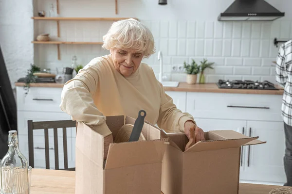 Überglückliche Rentnerin bereitet persönliche Sachen für Umzugstag vor — Stockfoto