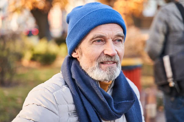 Cheerful gray-haired bearded gentleman sitting outdoors — Foto Stock