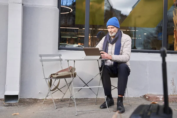 Mature male using tablet computer while spending time at the cafe at the street — Fotografia de Stock