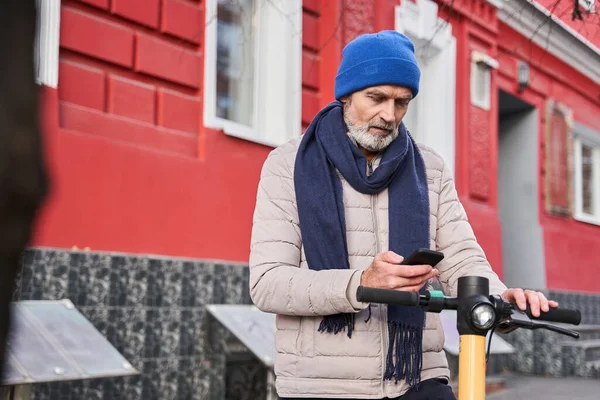 Millénaire homme caucasien senior en utilisant smartphone pour déverrouiller scooter de coup de pied urbain — Photo