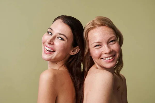 Ζωηρά κορίτσια γελούν δυνατά ενώ ποζάρουν πλάτη με πλάτη η μία στην άλλη. — Φωτογραφία Αρχείου
