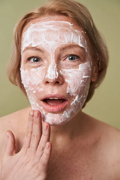 Mujer que se siente sorprendida de la nueva mascarilla mientras posa con la boca abierta —  Fotos de Stock