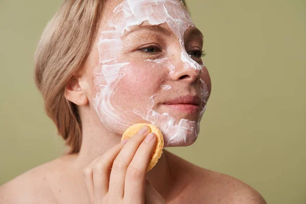 Mujer quitando máscaras de belleza mientras usa almohadilla cosmética y posando —  Fotos de Stock