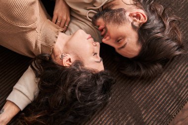 Sevgililer evdeki kanepede kucaklaşıyorlar.