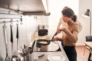 Çift kahvaltıda omlet hazırlıyor.