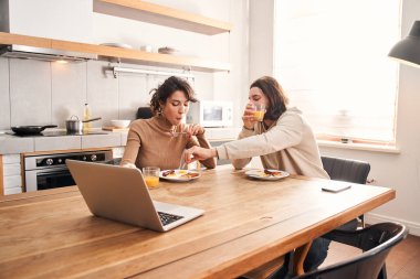 Adam karısının tabağından sosisi çatala batırır.