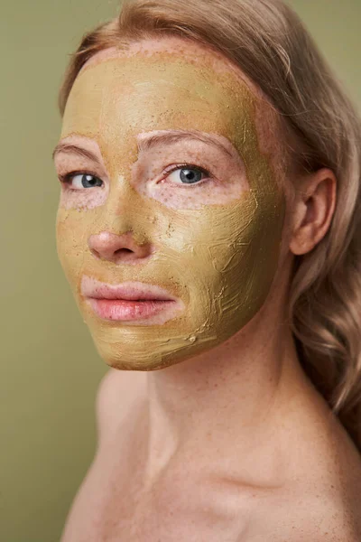 Woman with facial mask looking at the camera with calm expression — Stock Photo, Image