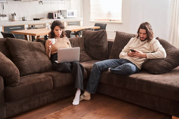 Duas pessoas pensativas usando gadgets em casa — Fotografia de Stock