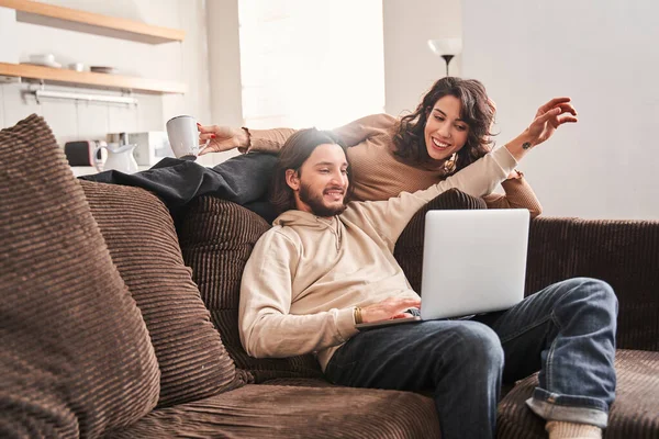 Donna sdraiata sul divano e guardando lo schermo del portatile — Foto Stock