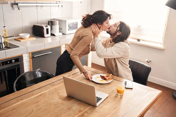 Mężczyzna całujący swoją kobietę przynoszącą mu śniadanie — Zdjęcie stockowe