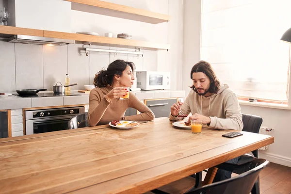 Par äter frukost när de sitter vid bordet i ett kök — Stockfoto