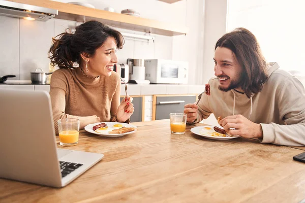 Par äter frukost när de sitter vid bordet i ett kök — Stockfoto