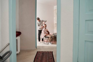 Yetişkin oğlu babasıyla oturma odasında vakit geçiriyor.