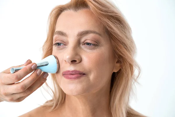 Mujer con piel perfecta usando dispositivo para cuidar su cara, aplicando procedimiento de spa — Foto de Stock
