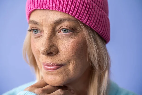 Serious freckled woman wearing hat looking away with calm expression — Stock Photo, Image