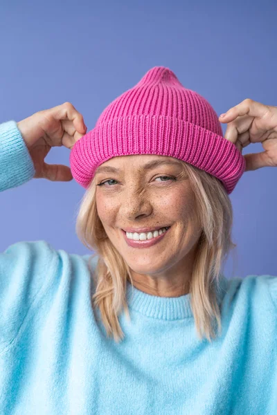 Reife Frau lächelt zahm und jubelt, während sie vor der Kamera posiert — Stockfoto