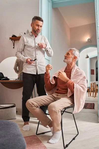 Pensioen vader en zijn volwassen zoon bespreken nieuw kapsel terwijl het doorbrengen van tijd thuis — Stockfoto