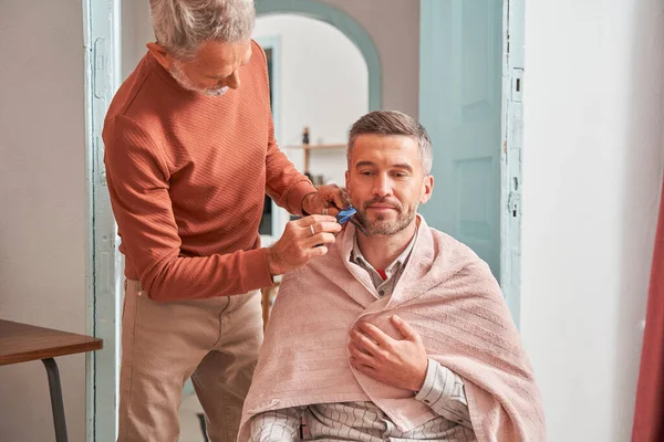 Volwassen man die thuis naar de kapper gaat tijdens quarantaine — Stockfoto