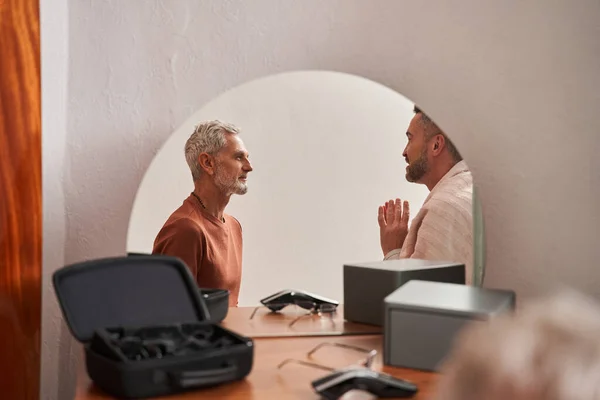 Rijpe zoon en zijn oudere vader zitten voor elkaar en hebben plezier gesprek — Stockfoto