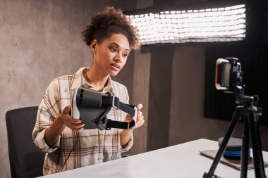 Tuğla duvara video kaydederken elinde vr gözlük tutan blog yazarı