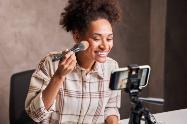 Çevrimiçi içerik oluşturucu yüzüne makyaj uyguluyor