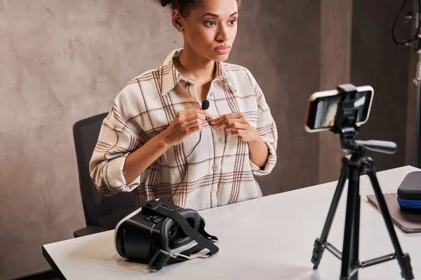 Donna vlogger mantenere il microfono a vestiti mentre si prepara a registrare il suo video blog — Foto Stock