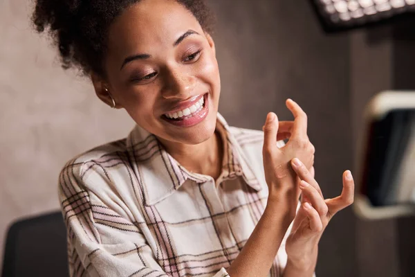 Blogger donna mostrando la mano con crema tono durante la trasmissione compongono tutorial — Foto Stock