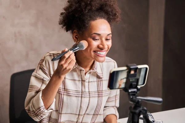 Online content creator applying a makeup on her face — Stock Photo, Image