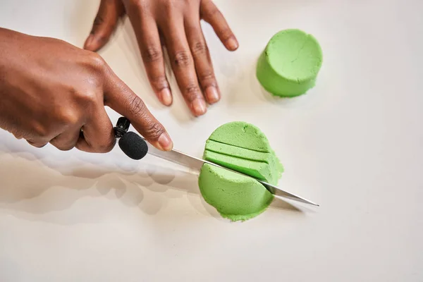 Multiracial chico cortar moldes de arena cinética verde y disfrutar del sonido —  Fotos de Stock