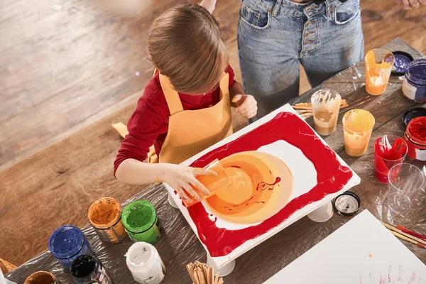 Cute schoolboy painting diligently at the table at the art school — Stock Photo, Image