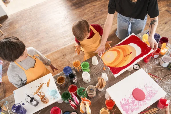 Niños pequeños dibujando cuadros con técnica de arte fluido juntos en la escuela de arte —  Fotos de Stock