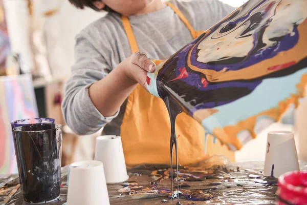 Pequeño chico caucásico de edad preescolar sosteniendo lienzo mientras dibuja la imagen en la técnica de arte fluido —  Fotos de Stock