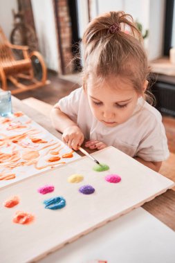 Özenli küçük çocuk parıltıya bakıyor ve resmi için onu seçmeye çalışıyor.