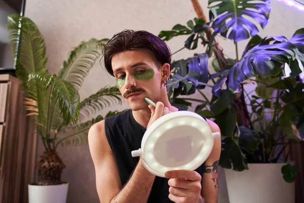 Przystojny mężczyzna masuje twarz, podnosząc zabieg twarzy, używając jadeitowego skrobaka — Zdjęcie stockowe