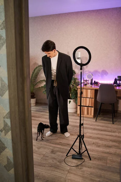 Man draagt stijlvol pak staan voor de lamp en de voorbereiding van het opnemen van zijn video blog — Stockfoto