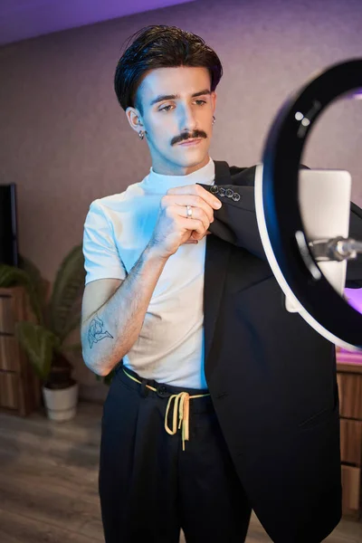 Metrosexual homme montrant à la caméra son costume avec un visage sérieux tout en enregistrant sa blo — Photo