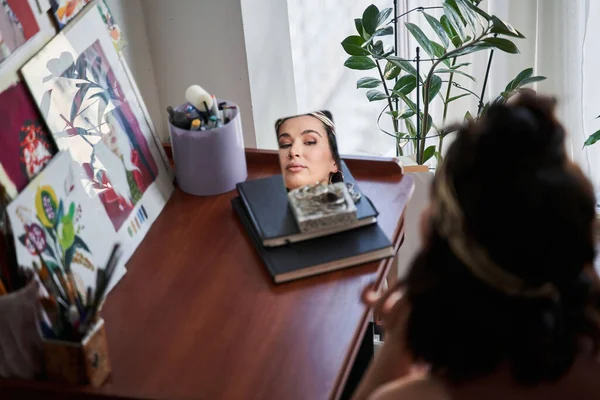 Caucásica mujer poniendo joyas a sí misma mientras que la creación de su mirada en casa —  Fotos de Stock