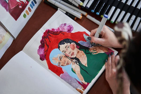 Grafica femminile utilizzando pennarelli mentre lavora alla sua nuova opera d'arte presso il taccuino — Foto Stock