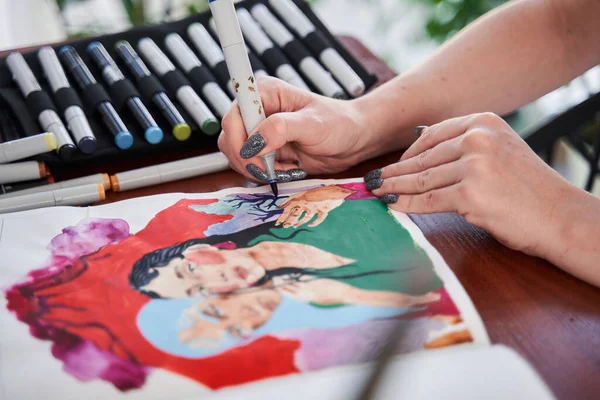 Kadın sanatçı masa değneğinde oturuyor ve evde renk piyasaları ile ilgili bazı çizimler yapıyor. — Stok fotoğraf