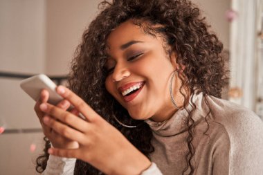 Çok ırklı bir kadın, izolasyon sırasında evde otururken sesli mesaj kaydediyor.