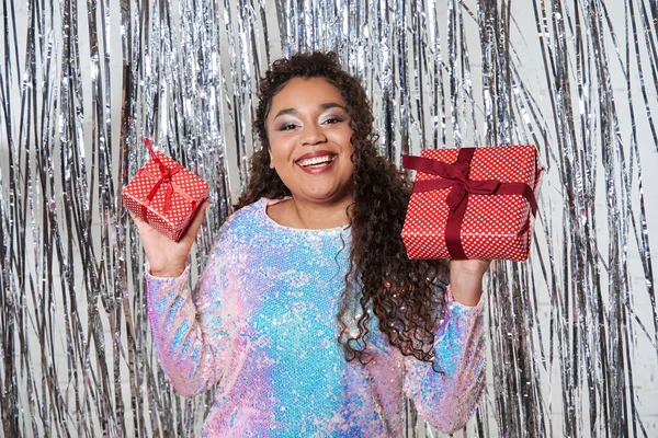 Модна жінка, показуючи камеру дві загорнуті подарункові коробки і усміхнений зубний при позі — стокове фото