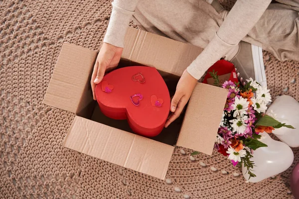 Mulher tomando caixa em forma de coração a partir do pacote armário ao recebê-lo de seu namorado — Fotografia de Stock