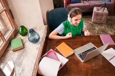 Gençler dizüstü bilgisayarın önünde otururken öğrenmenin keyfini çıkarıyorlar.