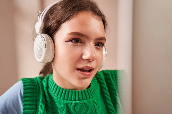 Adolescente caucásica con auriculares hablando por videollamada con su maestra — Foto de Stock