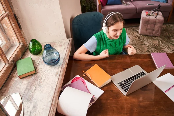 Gençler dizüstü bilgisayarın önünde otururken öğrenmenin keyfini çıkarıyorlar.