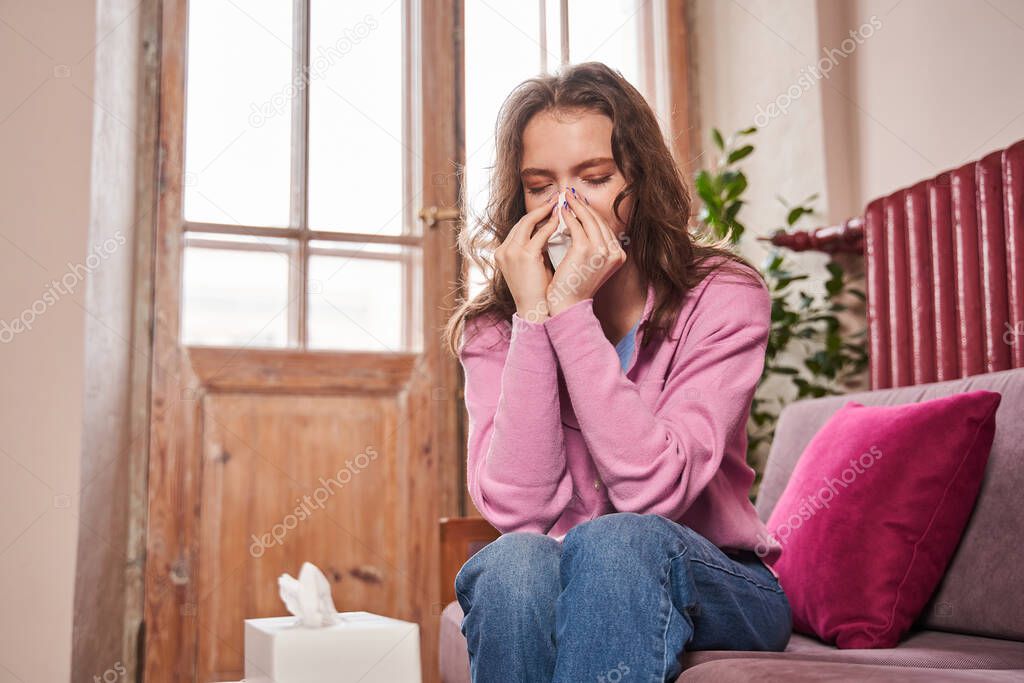 Upset caucasian teen child girl holding napkin and crying while sitting at the therapy