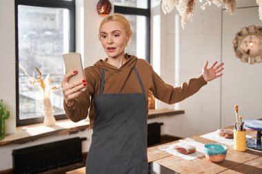 Duygusal blog yazarı kadın aboneler için blog videosunu kaydederken el kol hareketi yapıyor