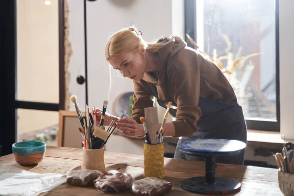 Tasarımcı ya da sanatçı çalışırken stüdyoda kilden heykel yapmaya hazırlanıyor.